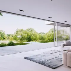 Nowoczesny salon z wygodnymi sofami i stolikami, przez ogromne okna panoramiczne widać bujną zieleń ogrodu.